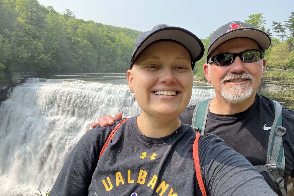 Emily Pacer and her father, Gary, stand in front of a waterfall. 
