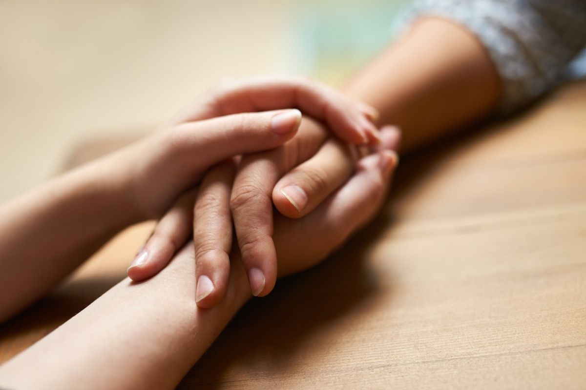 Two people holding hands across a table