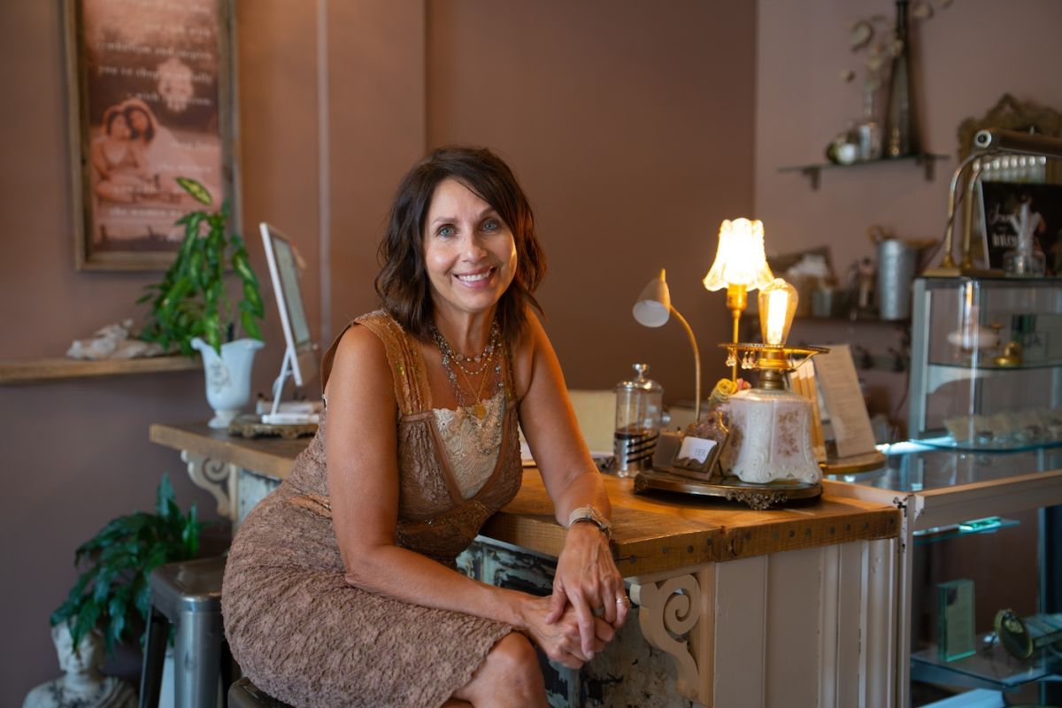 Susan Morreale, owner of HER Story and breast cancer survivor poses for a photo in her shop