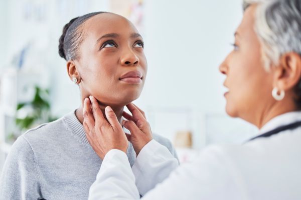 Woman getting her neck examined by a doctor