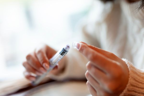 Woman holds a weight loss drug in the form of an injection in her hands.