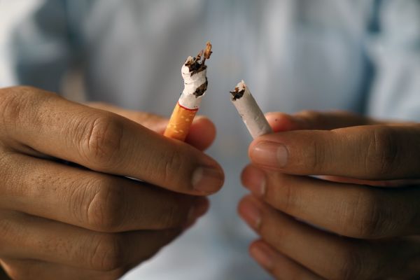 Hands breaking a cigarette in half