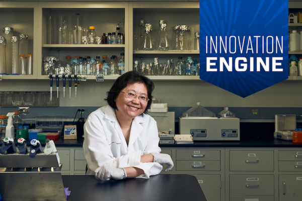 Dr. Li Tang stands in clinic smiling with the Innovation Engine badge