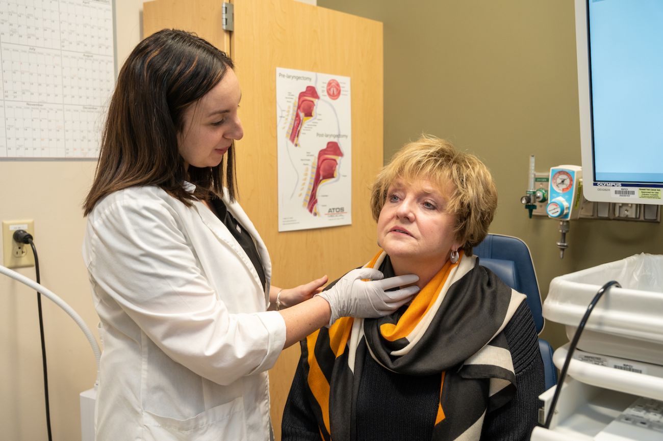Speech-language pathologist Sarah Crance examines the throat of a patient.
