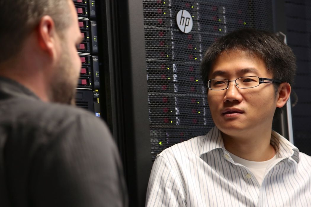 Scientist speaking in front of a rack of servers