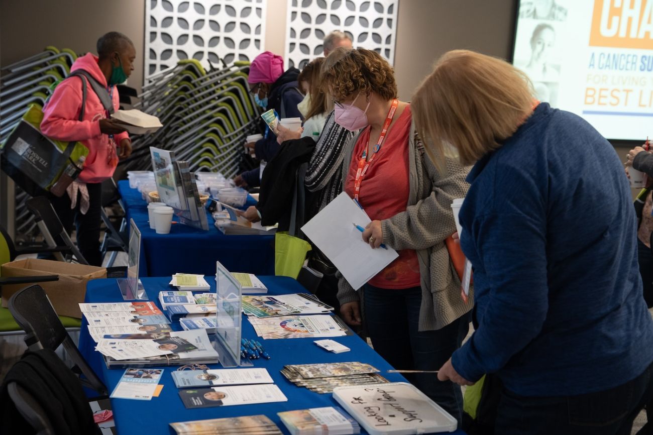 A group of Chapter 2 attendees look at a wellness table