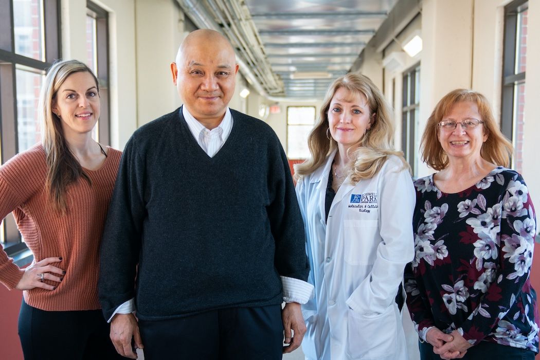 Team of scientists posing in a hallway